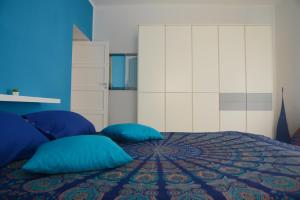 ein Schlafzimmer mit einem Bett mit blauen Kissen in der Unterkunft La Casa Di Nina in Matera