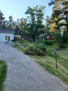 a gravel road with two parking meters next to a house at Cozy cottage on Värmdö in Djurhamn +1 photo