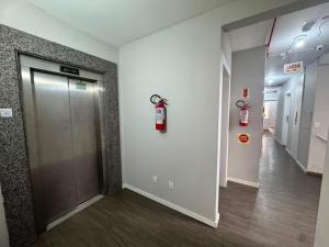 a hallway with a fire extinguisher on the wall of a building at iG Hotel - Canasvieiras in Florianópolis