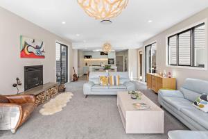 a living room with couches and a fireplace at 5 o'clock somewhere in Masterton
