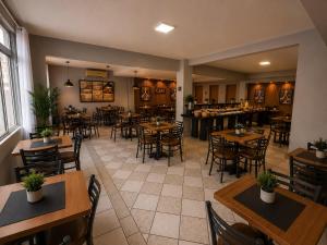 a restaurant with tables and chairs in a room at iG Hotel - Canasvieiras in Florianópolis