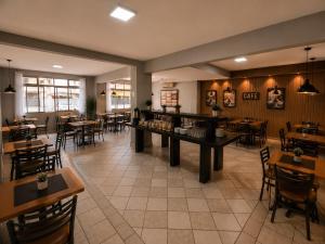 a restaurant with tables and chairs and tables and tablesktop at iG Hotel - Canasvieiras in Florianópolis