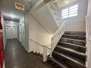 a hallway with stairs in a building with a exit sign at iG Hotel - Canasvieiras in Florianópolis