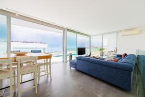 a living room with a blue couch and a table at Villa Veiga with heated pool in Callao Salvaje