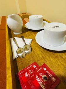 a wooden table with plates and bowls and spoons at Sun land Villa in Hikkaduwa
