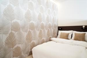 a bedroom with two beds and a wall with leaves at Stadtmauerloft - Premium Apartment in Eisenstadt