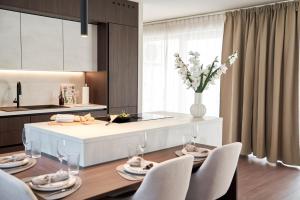a kitchen and dining room with a table and chairs at Stadtmauerloft - Premium Apartment in Eisenstadt