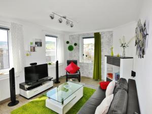 a living room with a couch and a tv at Fewo Penthaus-Blick in Willingen