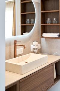 a bathroom with a sink and a mirror at Stadtmauerloft - Premium Apartment in Eisenstadt +30 photos