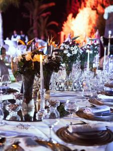 a table with glasses and vases with flowers on it at Villa zitoun in Aït Bou Zguia