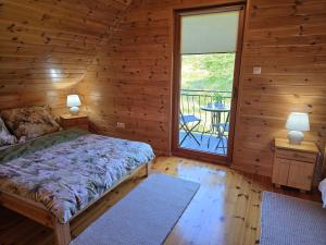 a bedroom with a bed and a window with a balcony at Morenowa Dolina Rusinowo in Rusinowo