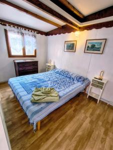 a bedroom with a bed with blue sheets and a wooden floor at Athena in Camporosso