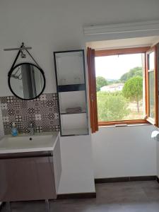 a bathroom with a sink and a mirror and a window at La maison de l'écluse in Trèbes