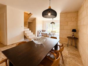 a dining room and living room with a table and chairs at Le Chai de Canteloup in Yvrac