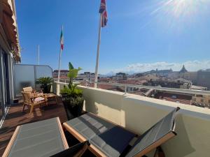 a balcony with chairs and a view of a city at Hôtel Cannes Centre Univers in Cannes