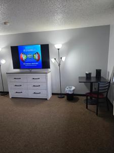 a room with a tv on top of a dresser at Fort Union Inn in Colstrip +10 photos