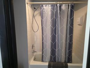 a shower with a shower curtain in a bathroom at Fort Union Inn in Colstrip