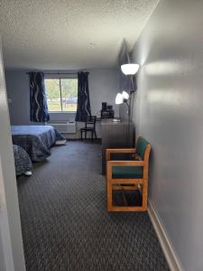 a bedroom with a bed and a chair and a desk at Fort Union Inn in Colstrip