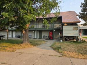 a house with a red door and a tree at Fort Union Inn in Colstrip