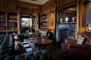 a living room with leather furniture and a fireplace at Dalhousie Castle in Bonnyrigg