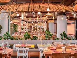 a dining room with tables and chairs and lights at Novotel Paris Porte Versailles in Paris