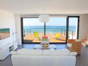 プルエスカにあるVilla de la plage de Plouescatのリビングルーム(白いソファ付)が備わり、海の景色を望めます。