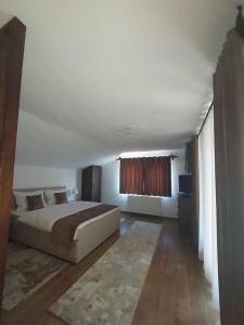 a white bedroom with a bed and a window at The Cozy Backyard Home- satu Mare in Satu Mare