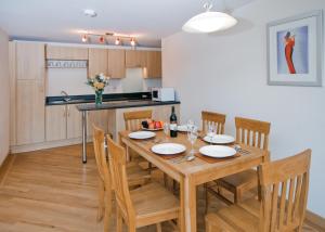 a dining room with a wooden table and chairs at Red Rock Apartments in Dawlish +2 photos