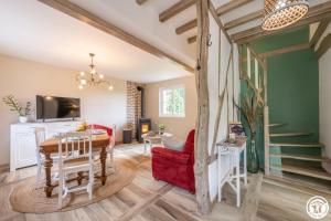 a living room with a table and a red chair at Le beloiseau in Breteuil