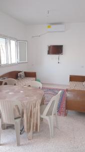 a room with a table and chairs and a couch at Najib in Djerba