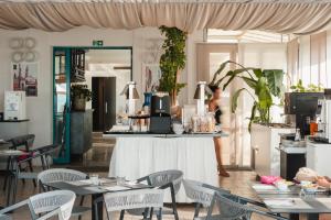 a restaurant with tables and chairs and a mirror at Hotel Delaville Frontemare in Lido di Jesolo