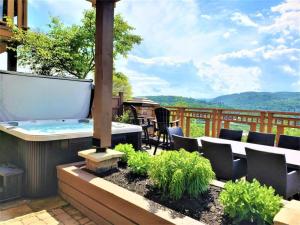 a patio with a hot tub and a table and chairs at Tremblant Prestige - Altitude 170-1 in Mont-Tremblant