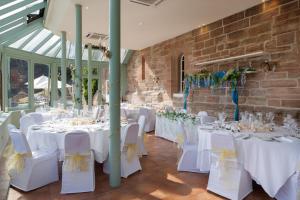 a room with white tables and white chairs at Dalhousie Castle in Bonnyrigg