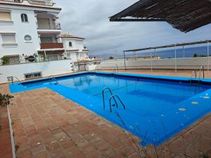 a swimming pool in front of a building at El Paraíso del Tesorillo in Almuñécar