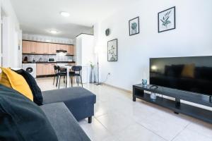 a living room with a couch and a flat screen tv at La Posadilla in Adeje