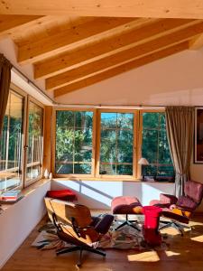 a living room with chairs and tables and windows at La Tzoumaz Lodge in La Tzoumaz