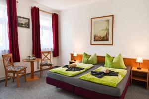 a bedroom with a bed with green pillows at Landhotel Peters - zwischen zwei Seen in Canow +45 photos