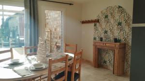 a dining room with a table and a fireplace at Gîte La Ferme Ecole in Perrou +6 photos