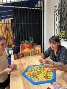 two women sitting at a table with a kiwi game at Til Sunrise in Cali
