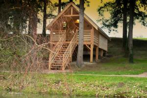 a tree house with a wooden staircase in the woods at La Cabane Spa De Céline in Voussac