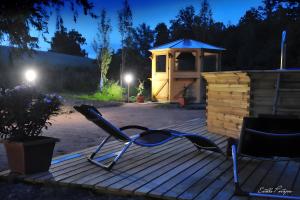 a deck with two chairs and a gazebo at night at La Cabane Forestière in Voussac +4 photos