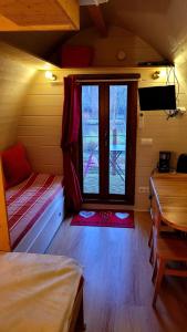a room with a bed and a window and a table at La Cabane Forestière in Voussac