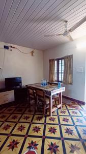 a room with a table and chairs on a rug at Verdant Vagamon Cottage in Vagamon