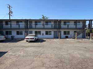 a white car parked in a parking lot in front of a building at Cinderella Motel in Wasco +7 photos