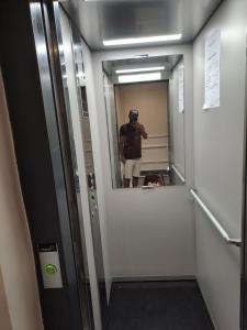 a man standing in front of a mirror in a elevator at Blue Horizon Mansouriah in Mohammedia