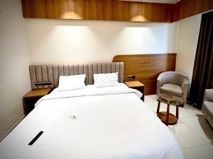 a bedroom with a large bed and a chair at The Novaire in Lucknow