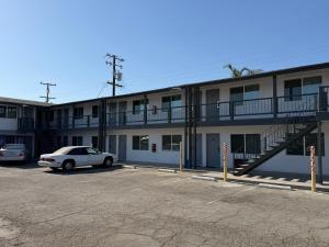 a car parked in a parking lot in front of a building at Cinderella Motel in Wasco