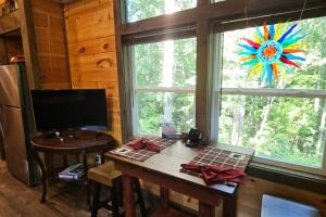 a desk in a room with a window and a table at Amazing Mountain View Tiny House in Hayesville