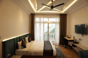a bedroom with a bed with a ceiling fan and a window at The Woods by CASA D' GAVA in Lucknow +11 photos