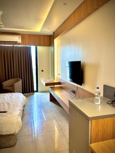 a hotel room with a bed and a tv on the wall at The Novaire in Lucknow
